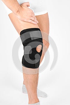 Knee Support Brace on leg isolated on white background. Elastic orthopedic orthosis. Anatomic braces for knee fixation