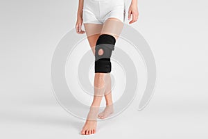 Knee Support Brace on leg isolated on white background. Elastic orthopedic orthosis. Anatomic braces for knee fixation