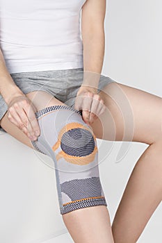 Knee Support Brace on leg isolated on white background. Orthopedic Anatomic Orthosis. Braces for knee fixation, injuries and pain.