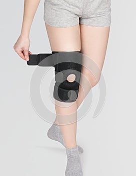 Knee Support Brace on leg isolated on white background. Orthopedic Anatomic Orthosis. Braces for knee fixation, injuries and pain.