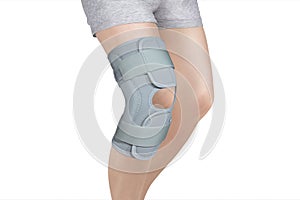 Knee Support Brace on leg isolated on white background. Orthopedic Anatomic Orthosis. Braces for knee fixation, injuries and pain.