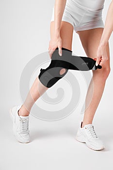 Knee Support Brace on leg  on white background. Elastic orthopedic orthosis. Anatomic braces for knee fixation