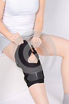 Knee Support Brace on leg  on white background. Elastic orthopedic orthosis. Anatomic braces for knee fixation