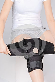 Knee Support Brace on leg  on white background. Elastic orthopedic orthosis. Anatomic braces for knee fixation