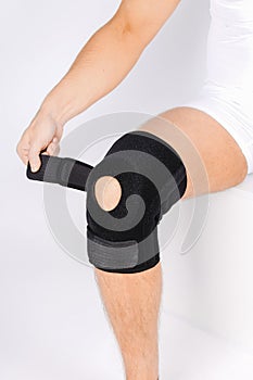 Knee Support Brace on leg  on white background. Elastic orthopedic orthosis. Anatomic braces for knee fixation