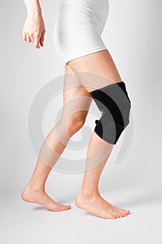 Knee Support Brace on leg  on white background. Elastic orthopedic orthosis. Anatomic braces for knee fixation