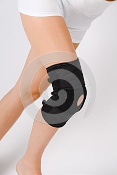 Knee Support Brace on leg  on white background. Elastic orthopedic orthosis. Anatomic braces for knee fixation