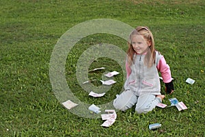 Kneeing little girl with money around photo