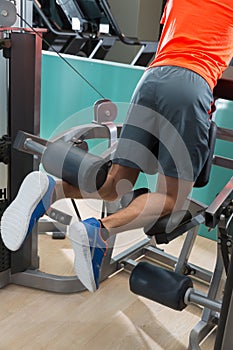 Kneeling leg femoral curl man at gym