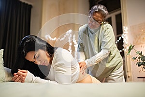 Kneeling pregnant woman and midwife at home