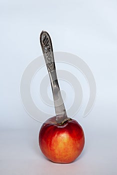 Knife in an apple on a white background