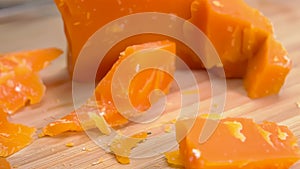 a knife breaks off a piece of hard Mimolette cheese