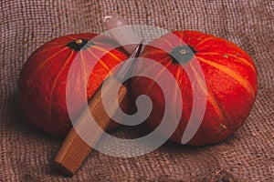 The knife and candle is leaning against two pumpkins