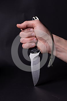 The knife is clenched in the hand. The hand is clenched into a fist