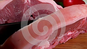 Knife cuts lamb steak on a wooden board