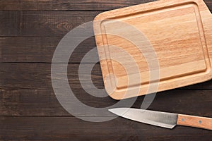 Knife and cutting board on the wooden background. Copy space for