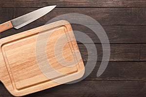 Knife and cutting board on the wooden background. Copy space for