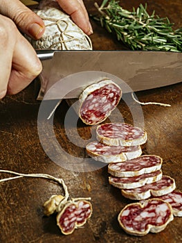 Knife cutting through cured meat