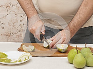 Knife cutting green pears on a cutting board