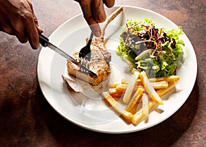 Knife cutting grilled pork chops steak Close up, Pork chop steak with salad and french fries