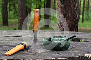 Knife and dishes of a tourist, hunter. Plastic dishes in the forest. photo