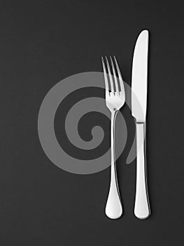 Knife and fork on black