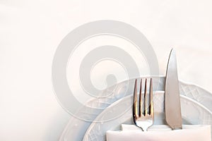 knife and fork in a folded napkin on two plate