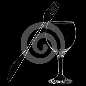 Knife and fork leaning on wine glass