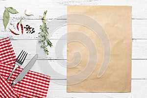 knife and fork on white old vintage wooden table with red checked tablecloth