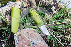 A knife with a green handle. Knife and plastic sheath.