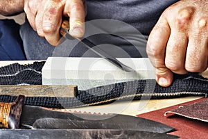 Knife in hand sharpening on a whetstone.