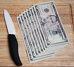 Knife and money on a chopping board