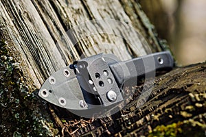 Knife with the plastic kydex sheath in the forest background