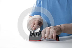 A knife sharpener. A man sharpens a knife on a special universal knife sharpener photo