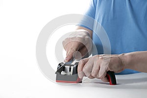 A knife sharpener. A man sharpens a knife on a special universal knife sharpener photo