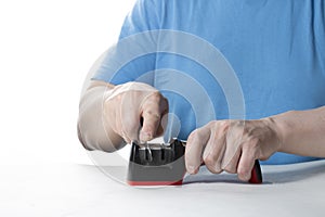 A knife sharpener. A man sharpens a knife on a special universal knife sharpener photo