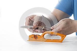 A knife sharpener. A man sharpens a knife on a special universal knife sharpener photo