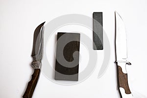 knife sharpening, knife on isolated white background with abrasive stone.