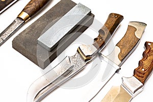 knife sharpening, knife on isolated white background with abrasive stone.
