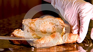 Knife spreading white butter on a toasted piece of crispy toast. Soft butter or cheese smearing on a sandwich close up