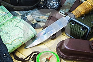 Knife surrounded by tourist equipment