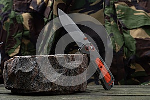 Knife upright on granite stone. Military concept.