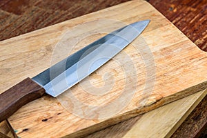 A Knifes on the brown wooden.