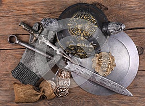 Knight armor, sword and shield on wooden