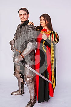 Knight in armor with a sword and a young woman in a medieval black dress. Love story. Married couple. Fantasy illustration for a