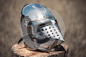 Knight, a brilliant helmet standing on a wooden stump