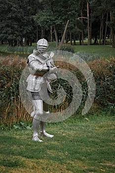 Knight in full armor with a sword against the background of a lake