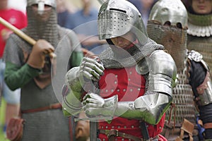 Knight in steel armor, holding hands sword in combat