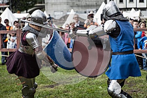 Knight tournament. The knights in the congregations are fighting in the ring. Public event in the city.