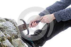 Knight tries to remove Excalibur sword in the stone